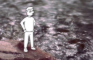Tiny Man Standing on a Rock by the River